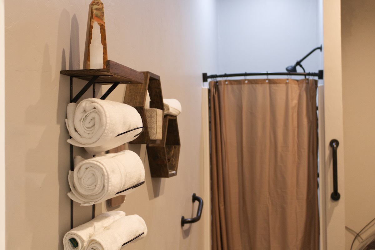 A photo of towels hanging on the wall next to a closed shower curtain