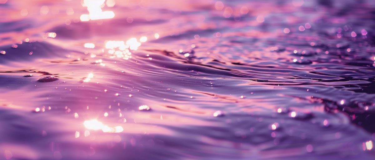 The surface of water with purple light reflected on it